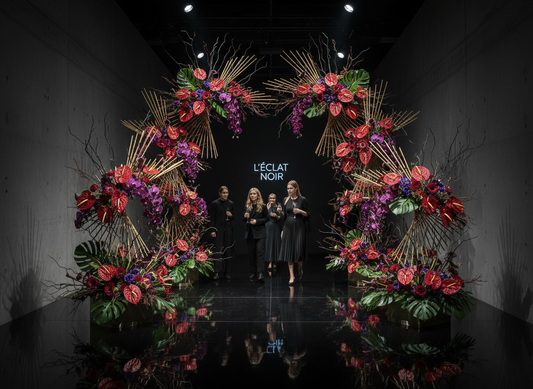 Floral archway with 'L'éclat Noir' branding at a fashion show.