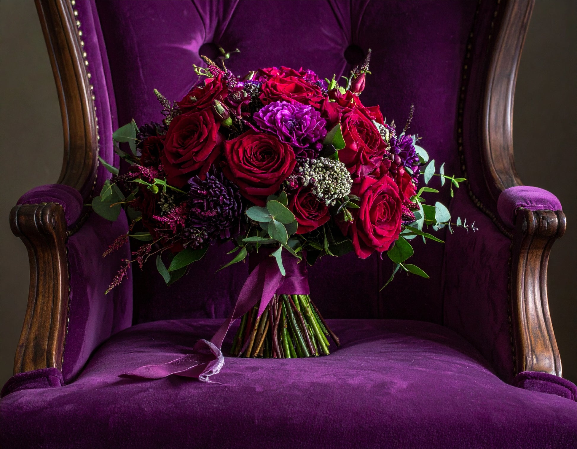 Bouquet of red and purple flowers on a purple chair
