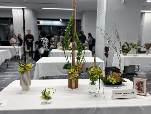 Decorative floral arrangements on tables in a conference room setting.