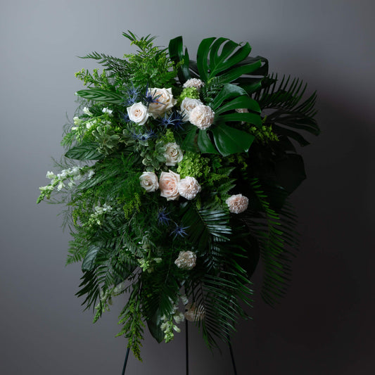 Floral arrangement with greenery and white flowers on a dark background
