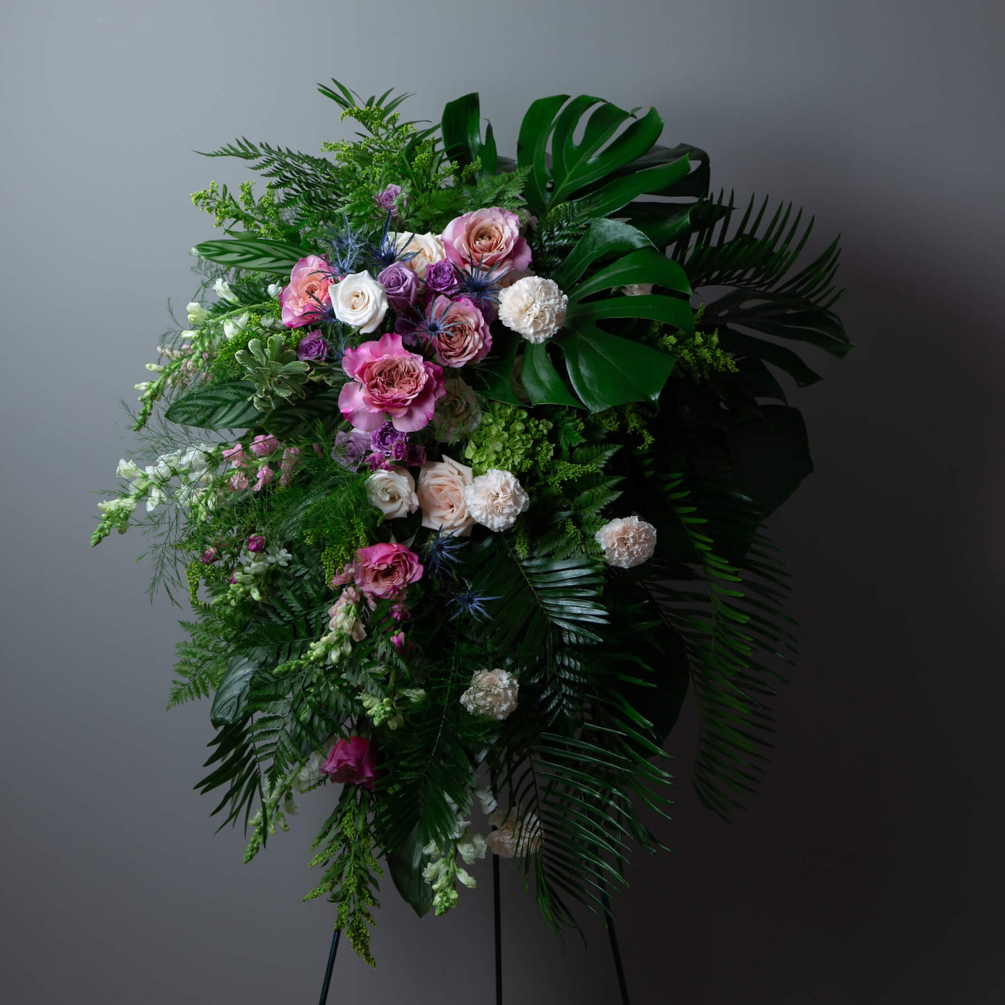Floral arrangement with pink, white, and purple flowers on a dark background
